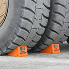 RubberXL heavy-duty wheel chock for preventing vehicle movement, made of durable rubber, shown in a secure parking setting.