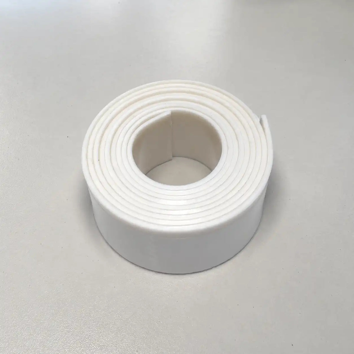 Flexible Teflon strip from RubberXL, durable and non-stick for industrial applications, shown in a close-up image.