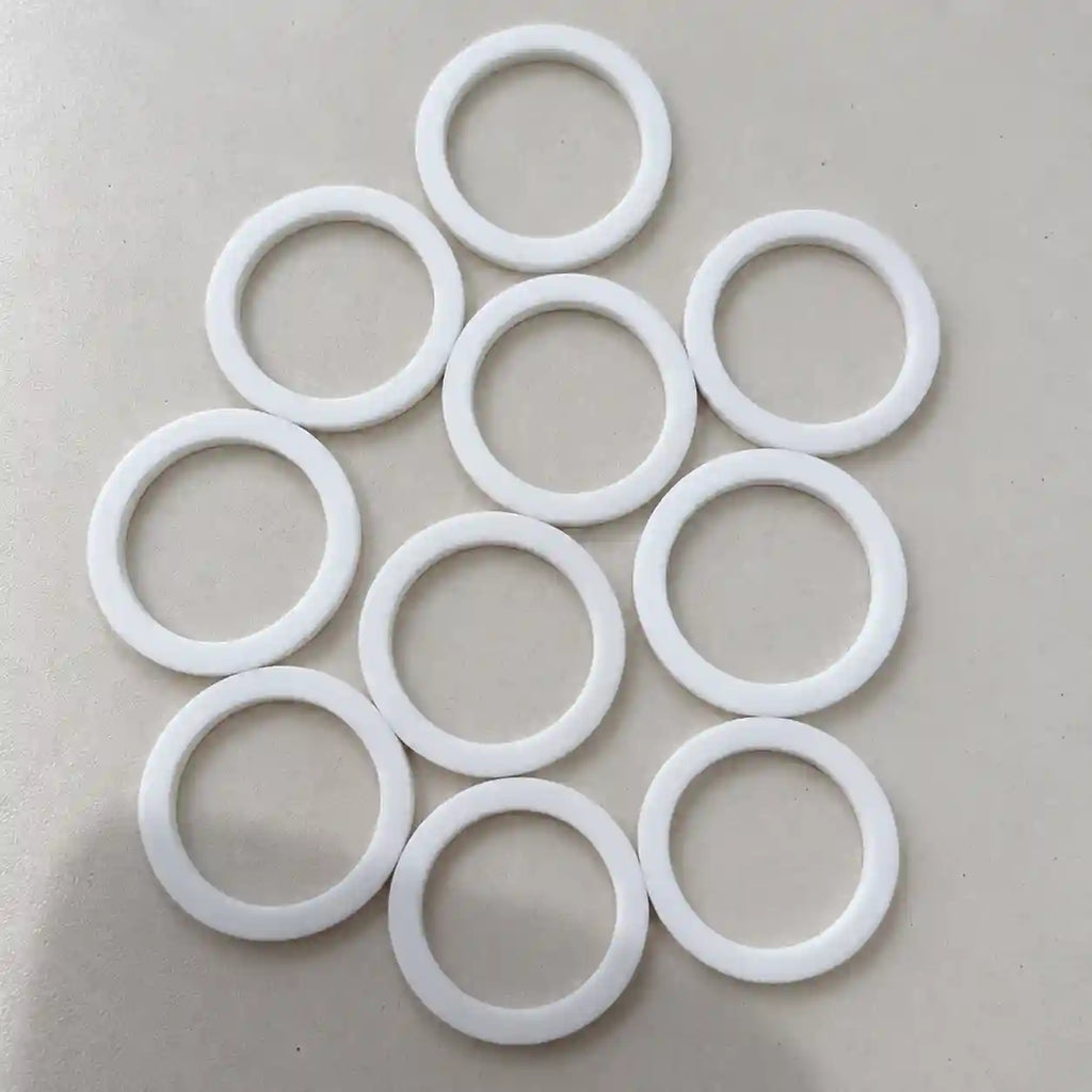 Small Teflon (PTFE) rings from BouwmarktXL, showing close-up of smooth, circular Teflon seals for industrial or DIY use.