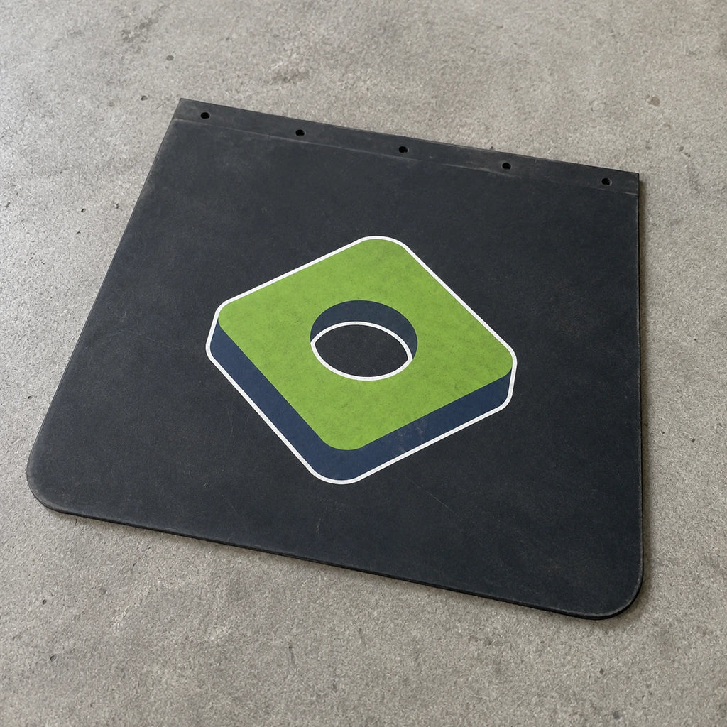Black rubber mudflap with BouwmarktXL logo, placed on concrete surface, showcasing durable truck accessory branding.