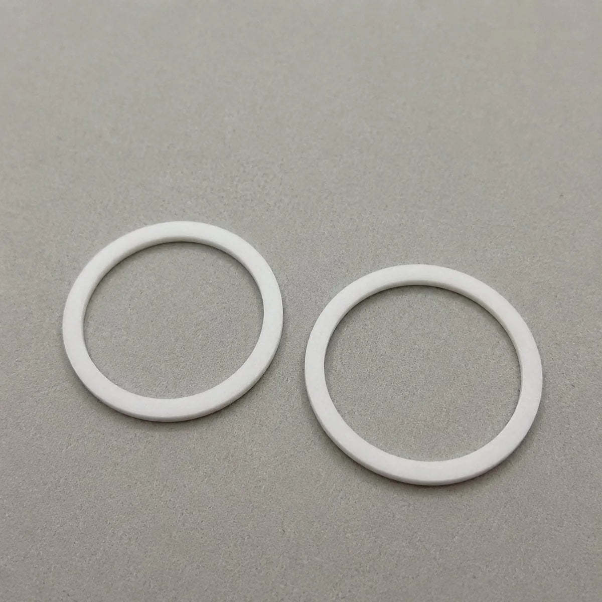 Two custom-sized Teflon rings made of plastic, designed for specific construction or DIY projects.