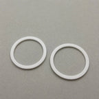 Two custom-sized Teflon (PTFE) rings from BouwmarktXL, showing smooth, white, high-performance plastic sealing components.